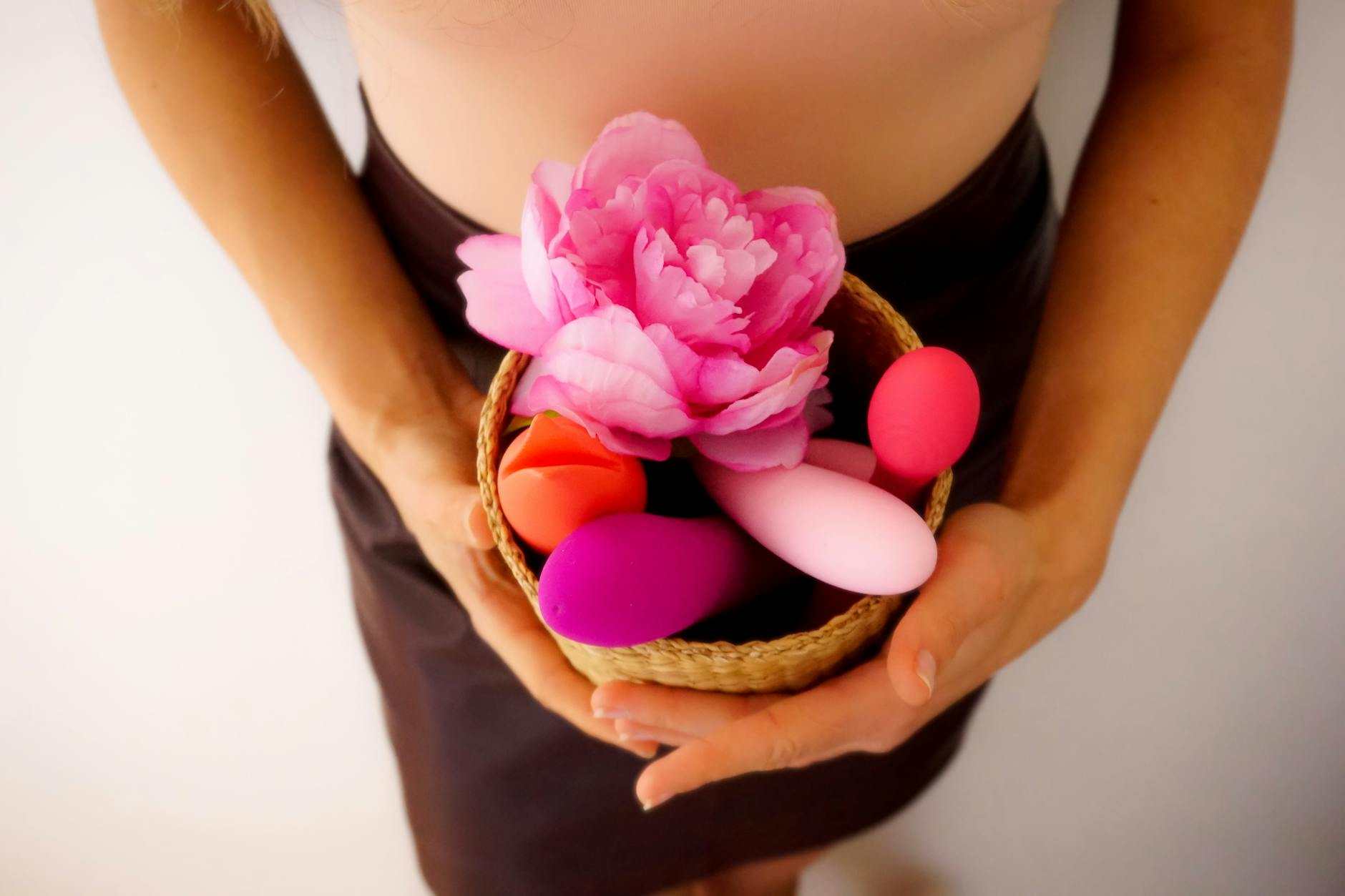 A basket of colorful vibrators and flowers, representing sensory reconnection and pleasure.